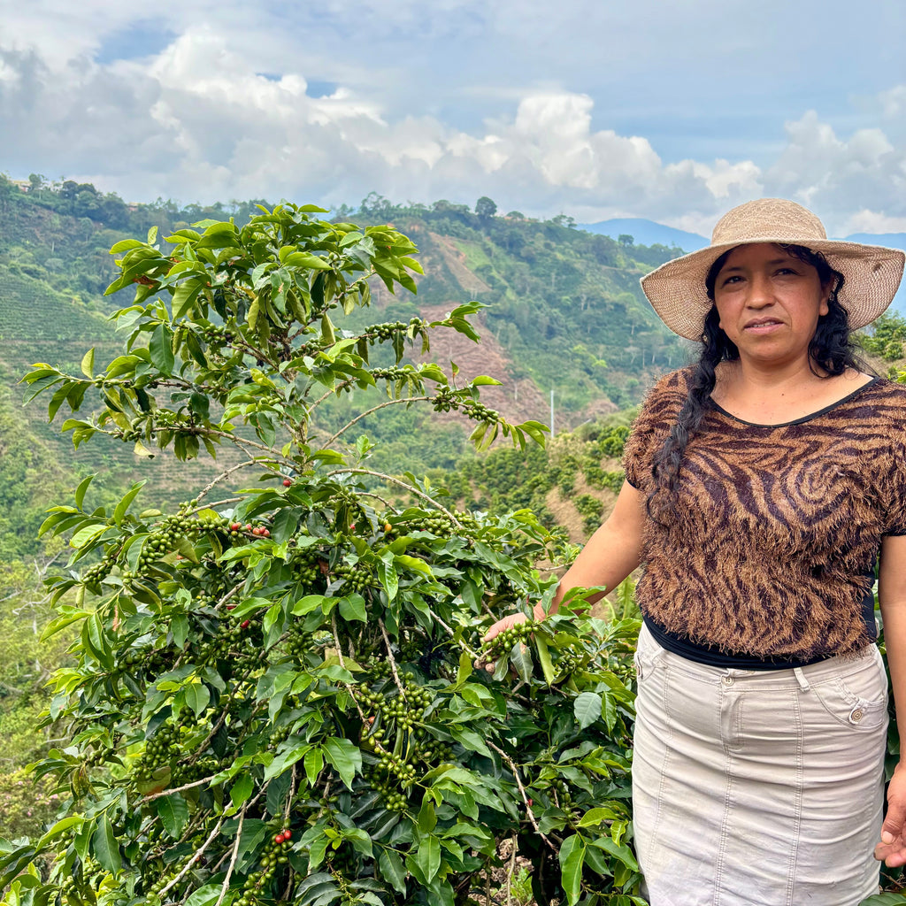 Martha Reina with one of her coffee trees at the highest elevation of her farm.